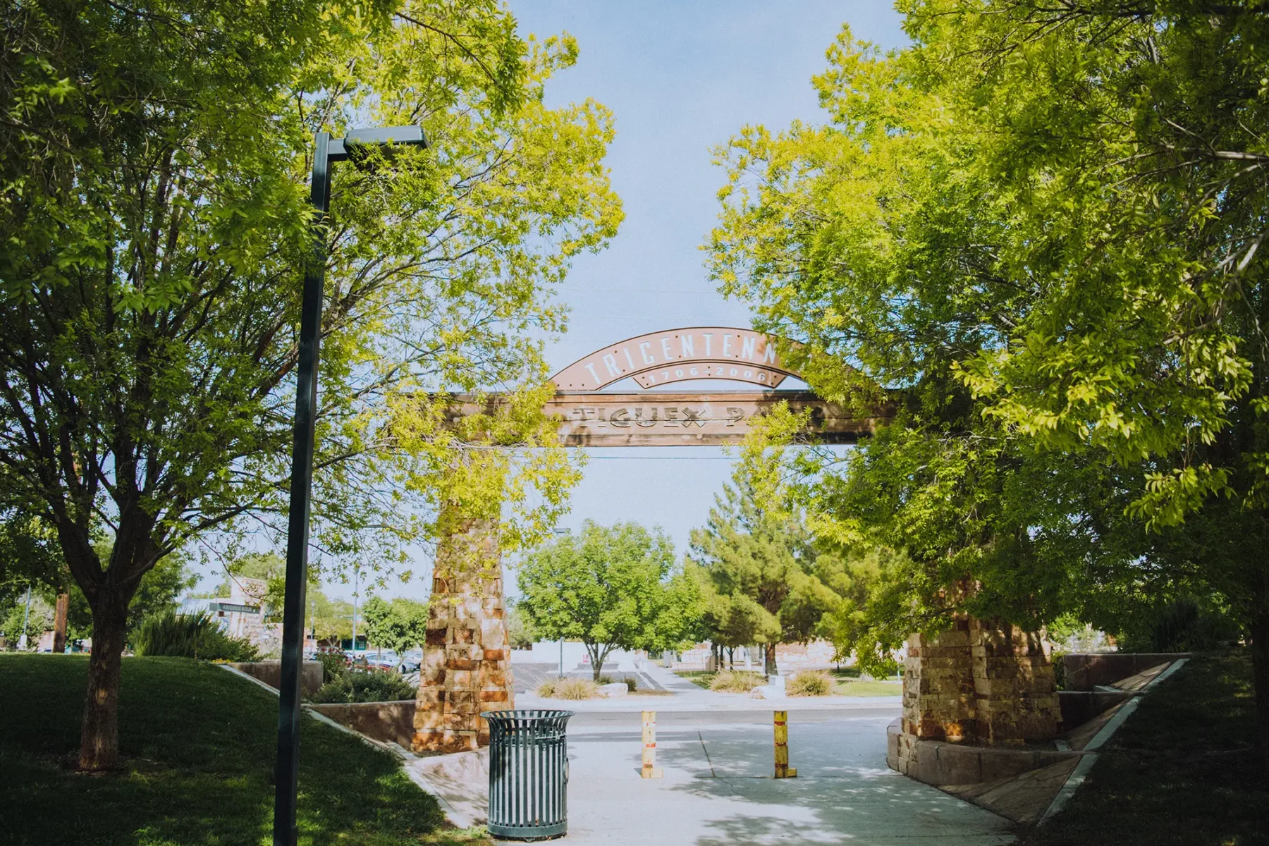 Entrance to Tiguex Park, lots of trees, paved sidewalk