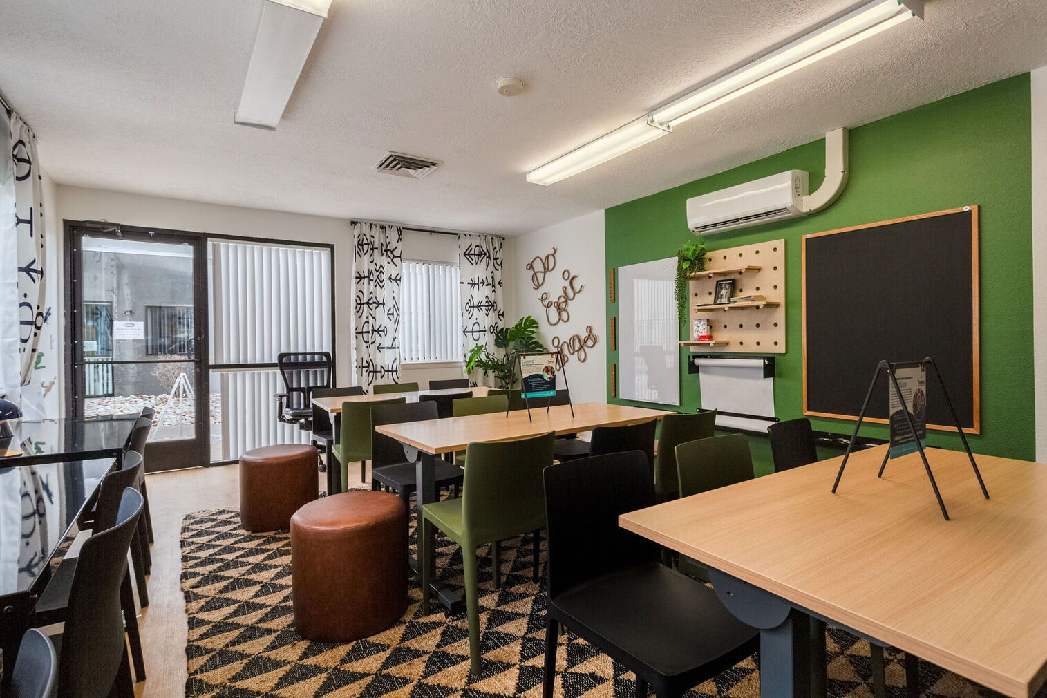 Kids club with desks and chairs, large windows, and shelves with books and games