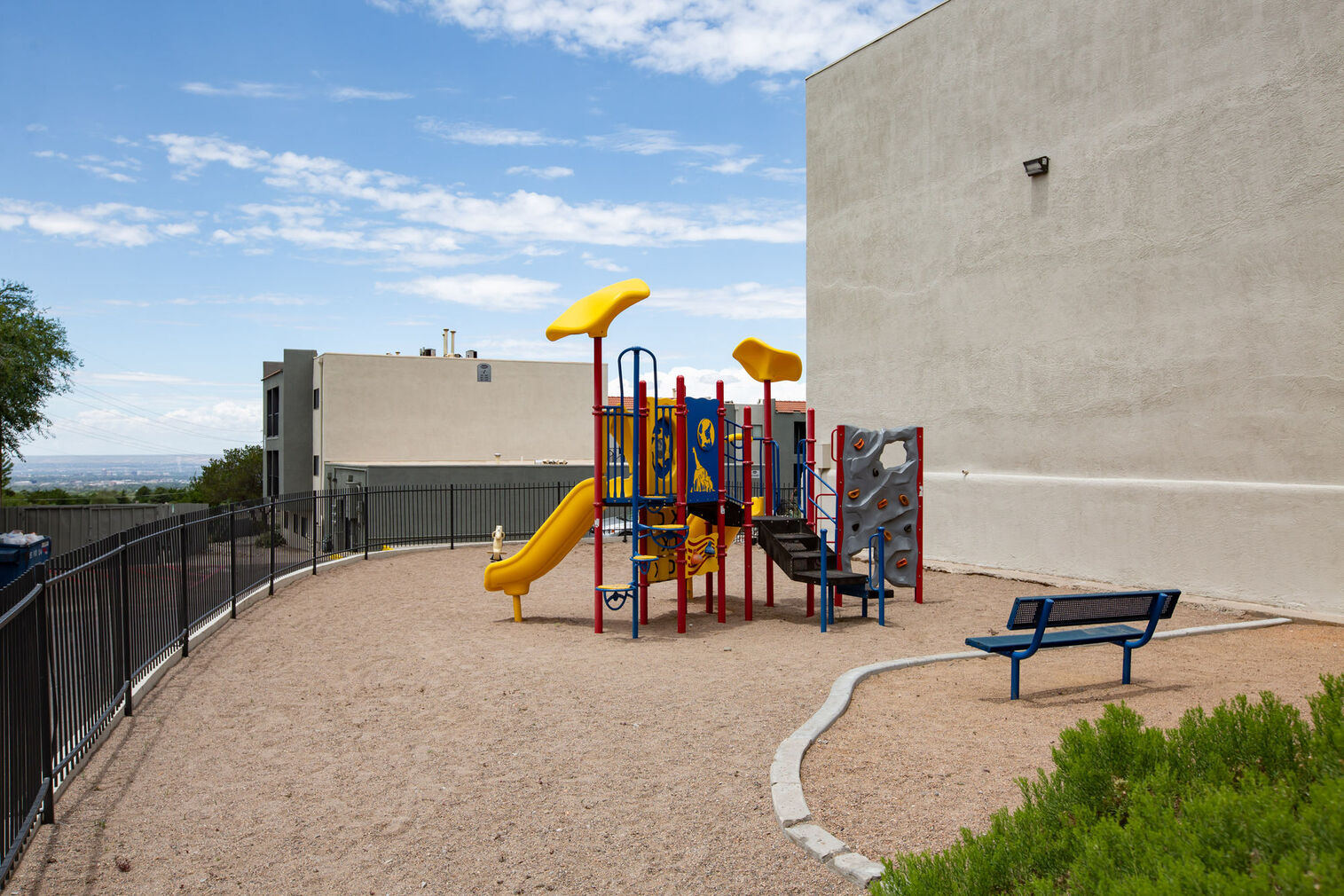 Fenced playground with climbing and slides