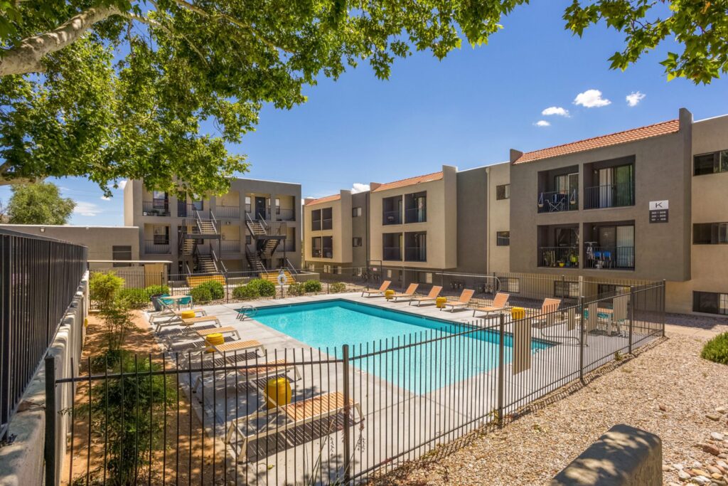 Pool with deck chairs and large shady trees