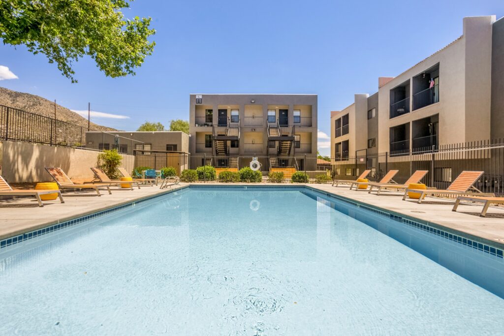 Pool with deck chairs and large shady trees