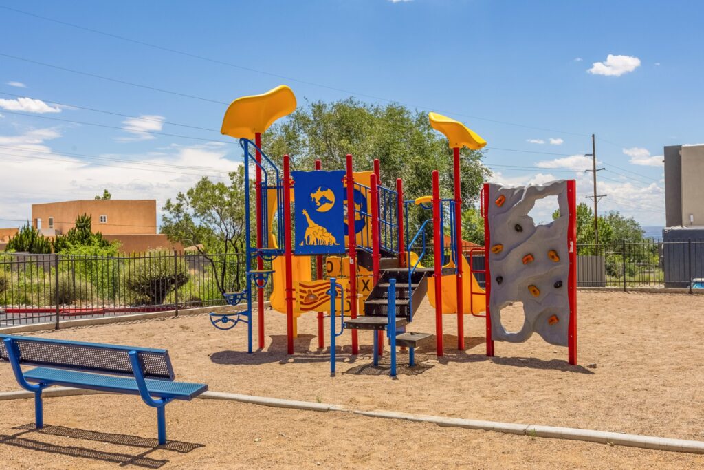 Fenced playground with climbing and slides