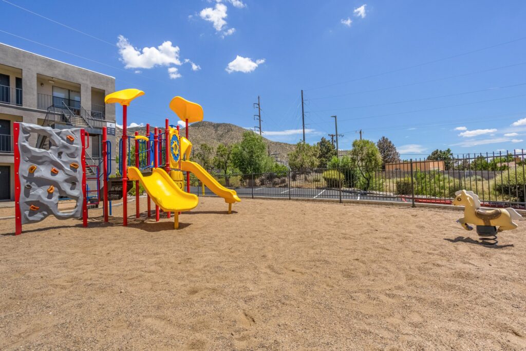 Fenced playground with climbing and slides